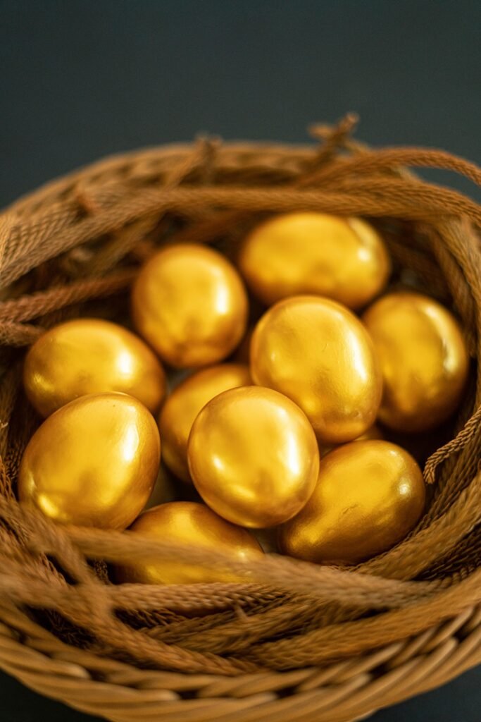 pexels-photo-16237713-16237713 Close-up of golden eggs elegantly arranged in a woven basket, symbolizing luxury and Easter themes.