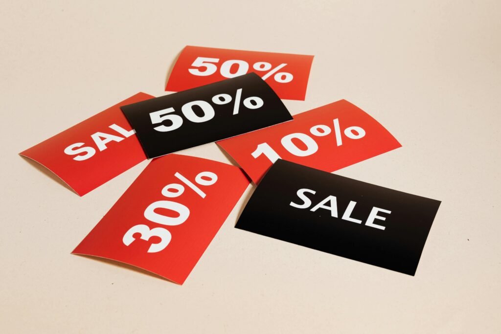 pexels-photo-5650026-5650026 Red and black sale tags showing various discount percentages on a beige background.